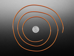 Long, orange LED filament coiled around a U.S. quarter for scale.