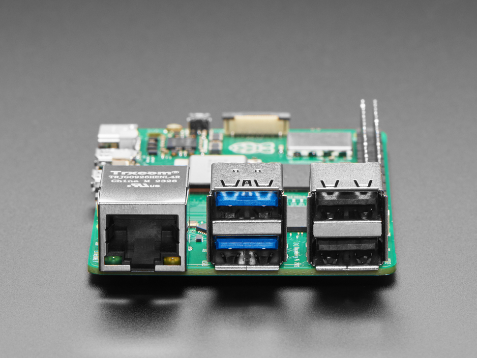 Close-up of Ethernet and USB-A jacks on green microcontroller.