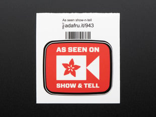 This is the As seen on show & Tell 
Square sticker displaying the Adafruit flower logo as a camcorder  